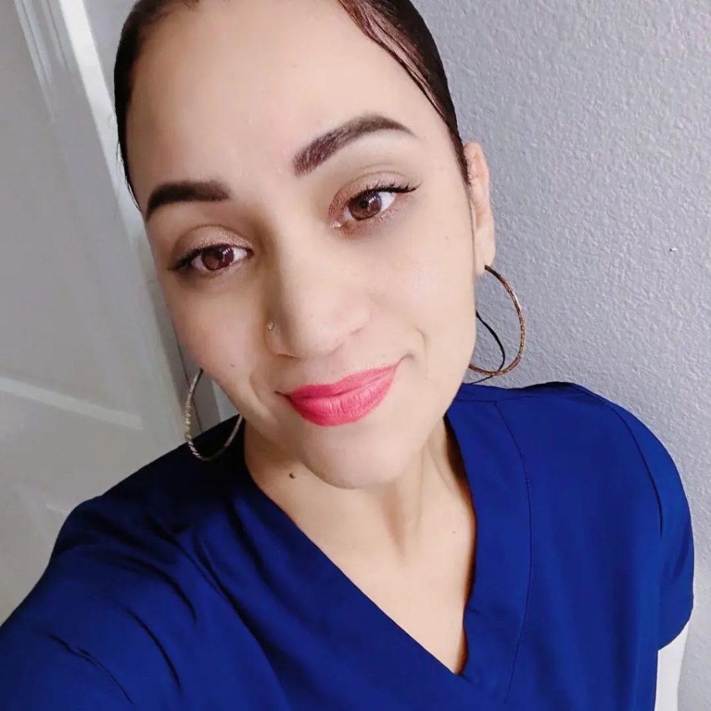 Smiling spa professional in blue uniform, representing friendly and welcoming staff at BGY Skin Aesthetics and Spa.